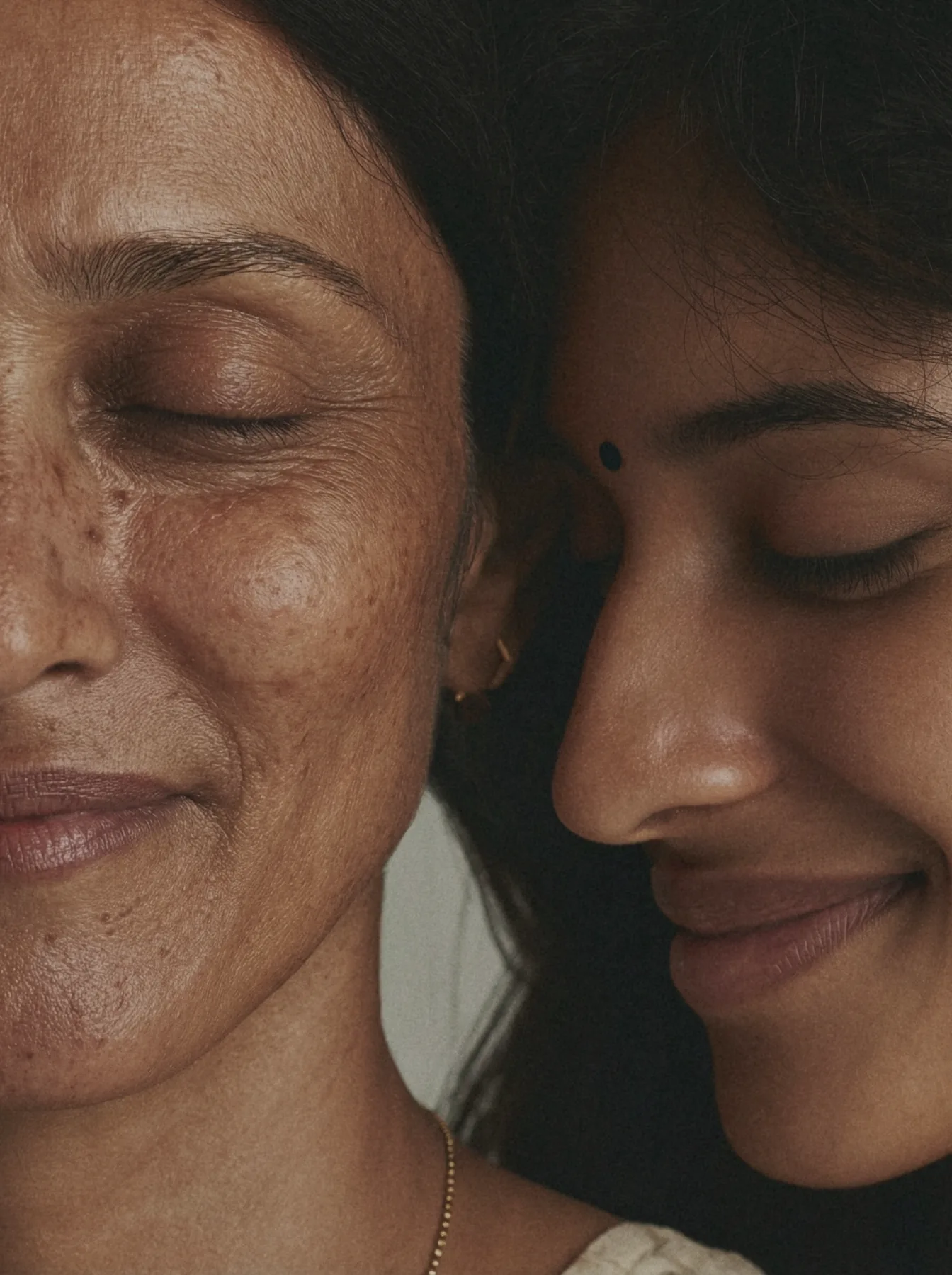 Older woman and younger woman resting cheek to cheek