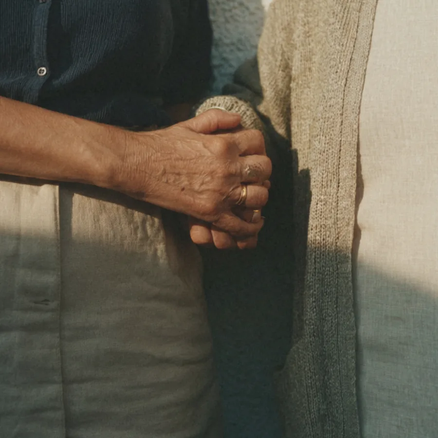 Two people holding hands in bed